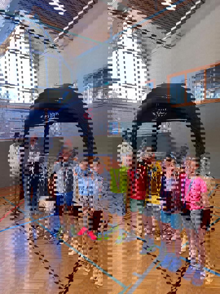 eine Gruppe von Kindern, die unter einem schwarzen Baldachin stehen